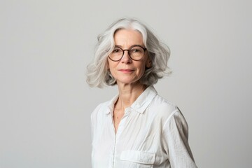 Older Woman White Background. Senior Female Doctor in Glasses Standing Confidently Against White Background
