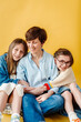 © Melissa Milis Photography/Stocksy - Family over yellow background studio portrait