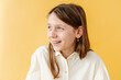© Melissa Milis Photography/Stocksy - Smiling girl in yellow background studio portrait