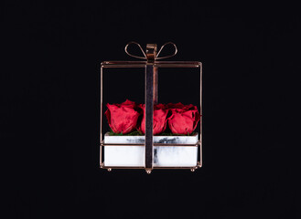 red gift artificial roses isolated on black background