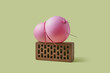 © Yaroslav Danylchenko/Stocksy - Pink balloon tied with thread to brick over green background