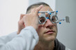 © Iuliia Versta/Stocksy - A man doing eye test checking examination with optometrist