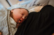 © Melissa Milis Photography/Stocksy - Sleeping newborn cuddled with mom