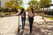 © Manu Padilla/Stocksy - Cheerful classmates chatting and walking on street on sunny day