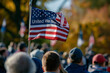 © Eugen - The flag bears the message 'United We Stand,' symbolizing unity and patriotism. It is frequently displayed during events and holidays such as Flag Day, and adorns shirts and poles amidst the crowd.