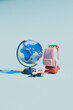 © Giada Canu/Stocksy - Blue Globe with Coral Backpack and Toy Airplane on Light Blue Ba