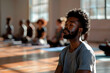 © Lucas - Image of a young adult African-American man meditating with a multi-ethnic group of people in a yoga class. Image with copy-space. Generative Ai.