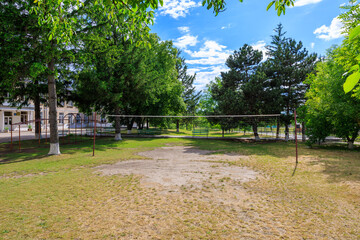 Wall Mural - A park with a volleyball net and a few trees