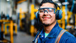 © Decord - Hispanic engineer wearing safety glasses and earmuffs standing inside industrial factory