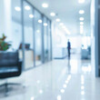 © mindstorm - A blurry image of a white office with a person walking down the hallway. The room is filled with light and has a clean, modern look