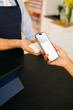 © Artem Podrez/Stocksy - Close-Up Phone Payment Process at shop