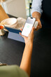 © Artem Podrez/Stocksy - Close-Up Phone Payment Process at shop