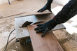 © Ezequiel Giménez/Stocksy - Crop carpenter cutting wooden board in workshop with electric saw