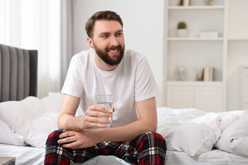 Sticker - Happy man with glass of water on bed at morning