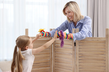 Wall Mural - Puppet theatre. Smiling mother and daughter performing show at home