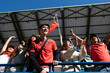 © BONNINSTUDIO/Stocksy - Enthusiastic fans cheering at a game in stadium