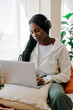 © BONNINSTUDIO/Stocksy - Woman enjoying music while studying on laptop at home