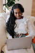 © BONNINSTUDIO/Stocksy - Smiling woman enjoying music on laptop