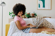 © BONNINSTUDIO/Stocksy - Cheerful woman enjoying time on laptop at home