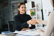 © Parichat - Businesswoman Shaking Hands in Modern Office Setting, Professional Meeting, Successful Partnership, Corporate Environment