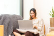 © CandyRetriever  - Asian woman freelance working on laptop computer with using AI browsing data at home. Businesswoman sitting on sofa in living room and remote working online corporate business and video conference.