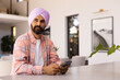 © Wavebreak Media - Using smartphone, man in turban sitting at home, looking thoughtful, copy space