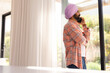© Wavebreak Media - Talking on smartphone, man in turban standing by window at home, copy space