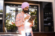 © Wavebreak Media - Using tablet, man in turban standing in modern kitchen, focusing on screen