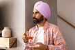 © Wavebreak Media - Holding cup of tea, man in turban standing and looking away
