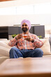 © Wavebreak Media - Sitting on couch, man in turban enjoying cup of tea at home