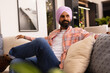 © Wavebreak Media - Relaxing on couch, man in turban wearing casual clothes at home