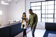 © Wavebreak Media - Discussing work, colleagues walking in modern office while using digital tablet