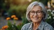 © VistaVisions - Smiling middle aged mature gray haired woman looking at camera, happy old lady in glasses posing outdoor in the park, positive single senior retired female sitting headshot portrait