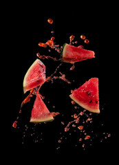 Wall Mural - sliced watermelon with watermelon juice splash on black background,stop motion