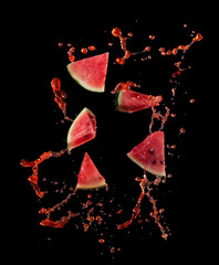 Wall Mural - sliced watermelon with watermelon juice splash on black background,stop motion