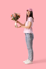 Wall Mural - Young delivery woman with bouquet of beautiful flowers on pink background
