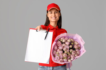 Sticker - Young delivery woman with bouquet of beautiful roses and clipboard on grey background