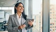 © Sain - Smiling mature professional business woman bank manager, older happy female executive or lady entrepreneur holding digital tablet pad standing in office at work, looking away at copy