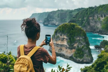 Wall Mural - a woman taking a picture of the ocean with her cell phone