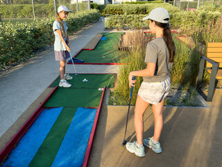 Wall Mural - teenage girls play mini golf