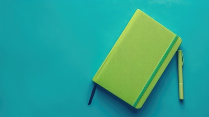 Wall Mural - Green notebook from above on blue surface