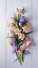 Pink and blue spring flowers on white wooden background