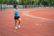 © chachamp - Asia mature woman Runner drill training on race track and field