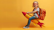 © Pingun - Happy child with backpack pretending to ride a rocket against yellow background. Imagination, fun, and adventure concept.