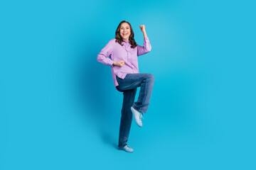 Canvas Print - Full length photo of lucky lovely woman wear violet shirt rising fists empty space isolated blue color background