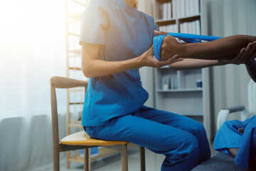 Professional physical therapist examines and cares for a young man in a physical therapy center, treating muscles and injuries of a man in a hospital.