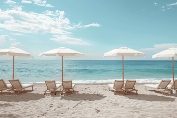 A beach scene with four white umbrellas and four white beach chairs