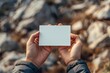 © Chanagun - Realistic human hands holding slender white business card on aerial background
