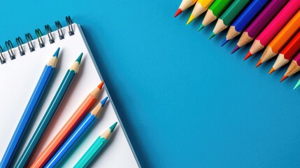 Wall Mural - Colorful pencils and blank sketchbook on bright blue background Art and hobby theme Top view with space for text