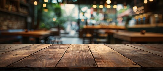 Poster - Empty brown wooden table with selected focus, blurred coffee shop background and bokeh effect create a suitable copy space image for product placement.